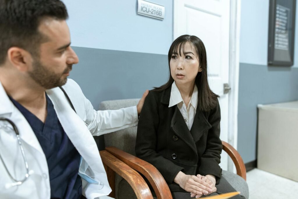 A doctor provides support to a patient in a hospital corridor, highlighting compassion in healthcare.